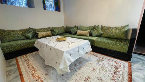 a living room with a couch and a table at Riad Dar El Ouedghiri in Fès