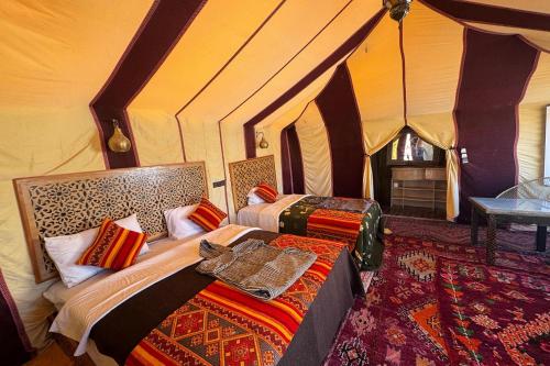 ein Schlafzimmer mit zwei Betten in einem Zelt in der Unterkunft luxury desert night camp in Merzouga