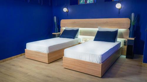 two beds in a room with blue walls at Riad Dar El Ouedghiri in Fès