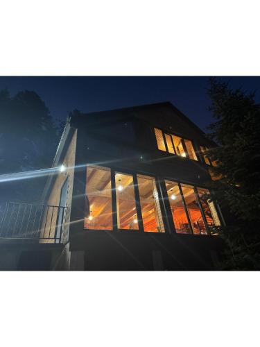 a building with illuminated windows at night at The Cotria's Chalet at GomisMta in Gomi
