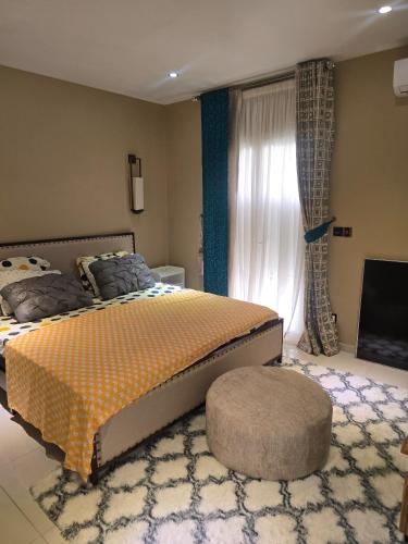 a bedroom with a large bed and a window at Le Champ des Roseaux - Kotto Douala in Douala