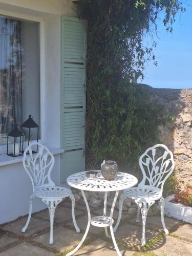 two chairs and a table and a table and chairs at La buganvilla en Udias alojamiento in Comillas