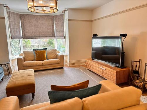 a living room with a couch and a flat screen tv at Lyme Regis Luxury Escape in Lyme Regis