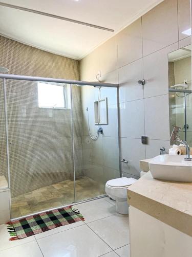 a bathroom with a shower and a toilet and a sink at Residencial Vicente Vaz in Patos de Minas