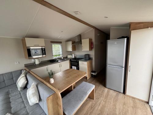 a kitchen with a wooden table and a refrigerator at Southview caravan park in Winthorpe