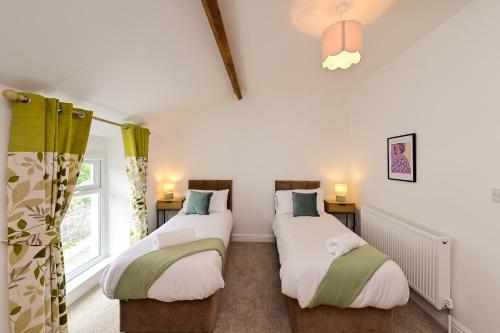 two twin beds in a room with a window at Cosy Mumbles Escape Fun & Relax in The Mumbles