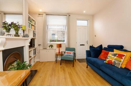 ein Wohnzimmer mit einer blauen Couch und einem Kamin in der Unterkunft Lockwood Cottage, Close to Monk Bar, sleeps 4 in York