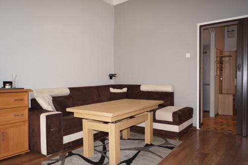 a living room with a couch and a wooden table at Mieszkanie na Nadodrzu in Wrocław