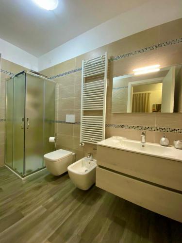 a bathroom with a sink and a toilet and a mirror at Green Door in Vieste