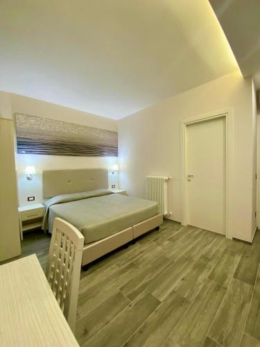 a bedroom with a bed and a table and a door at Green Door in Vieste