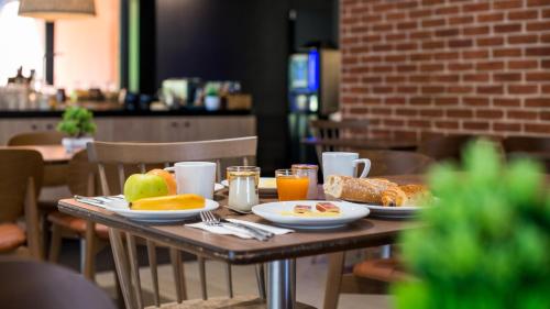 a table with breakfast foods and drinks on it at Campanile NATURE - Cahors in Cahors