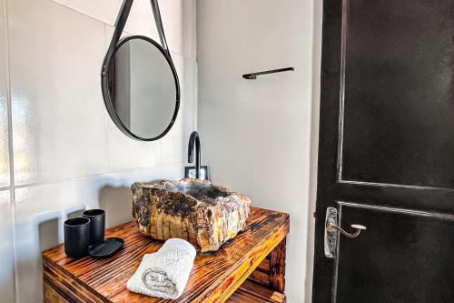 W łazience znajduje się lustro oraz drewniany stół z umywalką. w obiekcie Villa Rustica w mieście Arraial do Cabo
