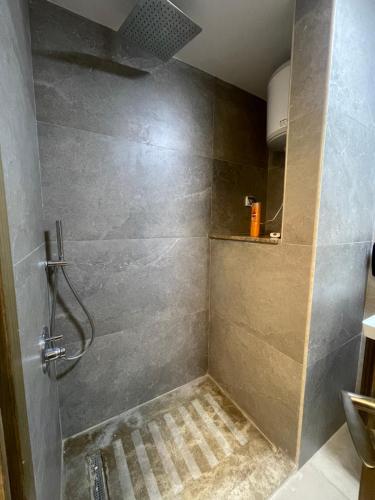 a bathroom with a shower with a tile floor at Luxury Studio Zed Park Compound Sheikh Zayed in Sheikh Zayed