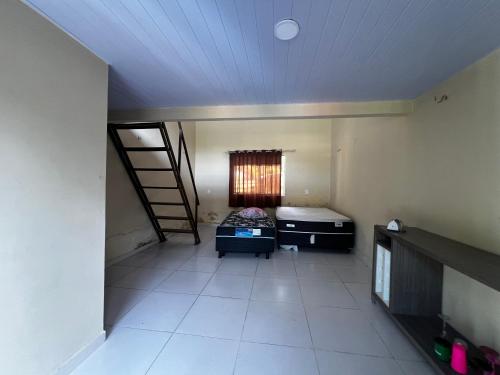 an empty room with a bed and a ladder in it at Chácara Aicram in Barcarena