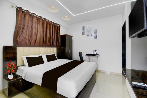 a bedroom with a large bed and a flat screen tv at Townhouse Sapphire Star Chappan Market in Indore