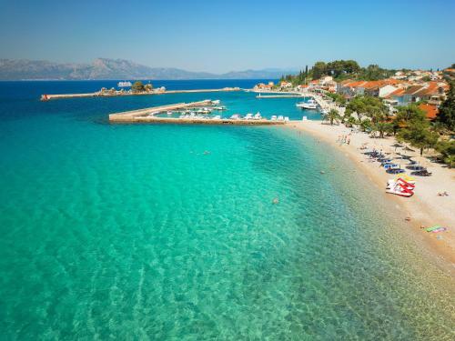 an aerial view of a beach with people in the water at Hotel Faraon in Trpanj