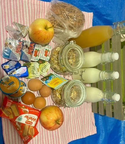 a table with apples eggs and other food on it at Apartmani DA in Piran