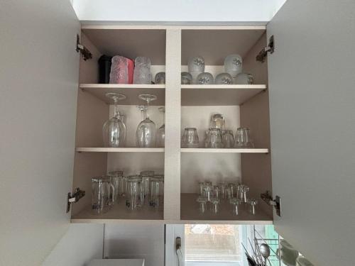 a kitchen cabinet filled with glass jars and vases at House of Rising Sun - Nanhee House in Incheon