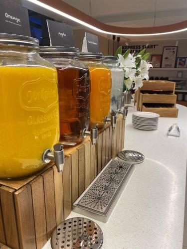 a row of jars of orange juice on a table at Holiday Inn Express Windsor by IHG in Windsor