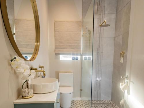 un baño con lavabo y ducha en Waves & Whales, en Brenton-on-Sea