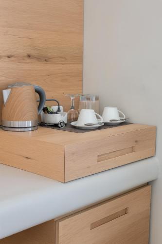 a kitchen counter with three appliances on a wooden shelf at Chic Hotel Santorini in Firostefani