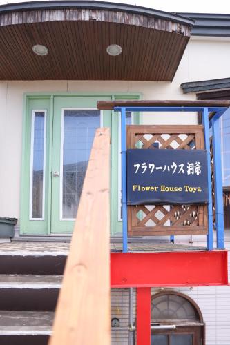 a house with a flower house top sign on it at Flower House Toya in Lake Toya
