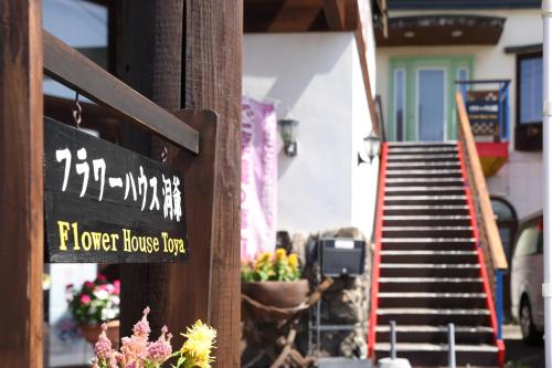 a house with a sign for a flower house dog at Flower House Toya in Lake Toya