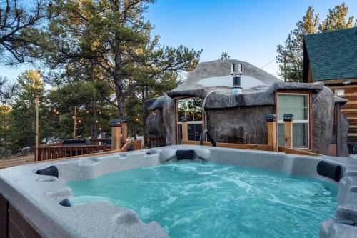 an outdoor hot tub in front of a house at Cave Cabin Hot Tub Fire Pit MTN Experience in Florissant