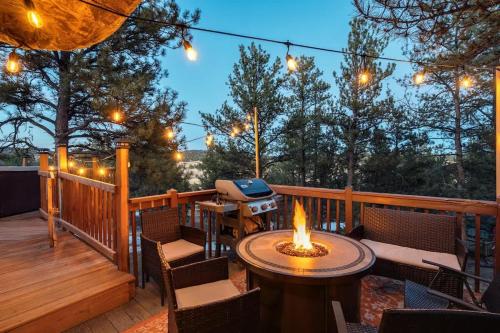 a deck with a table and chairs and a grill at Cave Cabin Hot Tub Fire Pit MTN Experience in Florissant