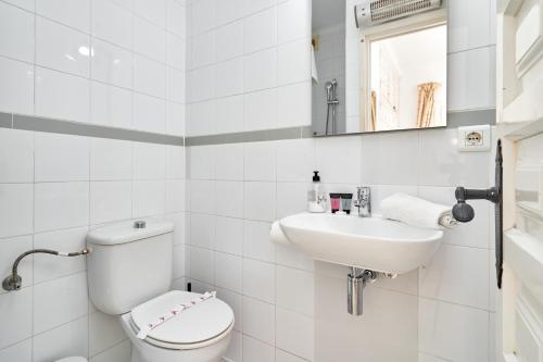 Un baño blanco con inodoro y lavabo. en Casa Mimosa Capistrano Nerja, en Nerja