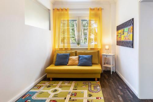 a yellow couch in a room with a window at Ferienhaus Optikstadt Rathenow in Rathenow