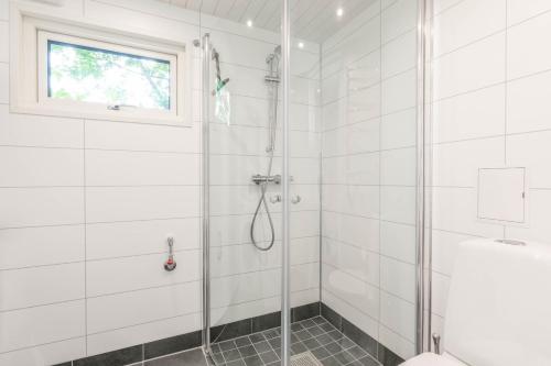 a white bathroom with a shower and a window at Åre Travel - Villa Solbringen eller Lilla Sol in Åre