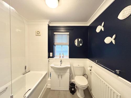 a bathroom with a tub and a toilet and a sink at Apartment I Sleeps 4 I Wi-Fi I Parking I Rail Links I Newmarket in Newmarket