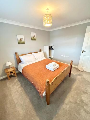 a bedroom with a large bed with an orange blanket at Apartment I Sleeps 4 I Wi-Fi I Parking I Rail Links I Newmarket in Newmarket