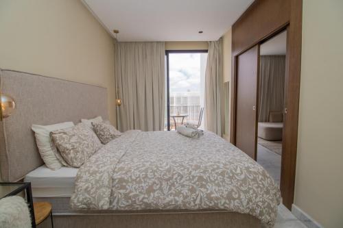 a bedroom with a bed and a view of a bathroom at Beautiful Studio in Oasis - Gym access & Balcony & Free Parking & Wifi Fiber in Casablanca