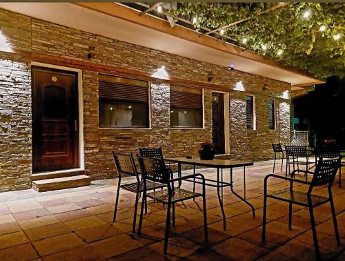 a patio with chairs and a table in front of a brick building at Petroula Suites Pozar in Kato Loutraki