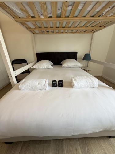 a bedroom with a large white bed with two watches on it at Modern Family - Disneyland Paris in Montévrain