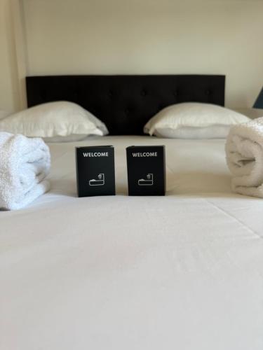 two signs on a bed with towels on it at Modern Family - Disneyland Paris in Montévrain