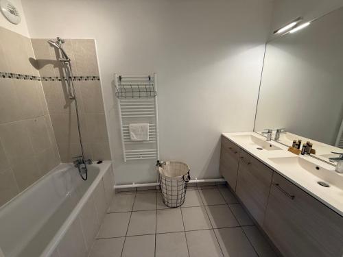 a bathroom with a tub and a sink and a mirror at Modern Family - Disneyland Paris in Montévrain