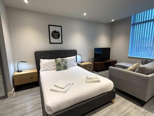 a bedroom with a bed and a living room with a couch at Stylish Studio in Bracknell with free Parking in Bracknell