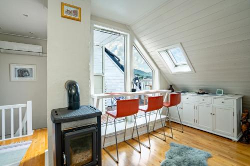 a room with a fireplace and a table and chairs at Privat rom i koselig Bergenshus in Bergen