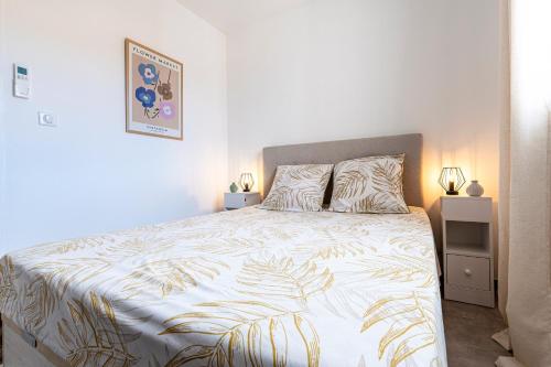 una camera da letto con un letto grande con un copriletto bianco di L'Île de Beauté - Climatisé a Agnarelu