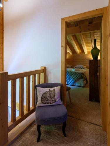 a cat laying on a pillow on a chair in a room at Chalet LE VAL NESS in La Côte dʼArbroz