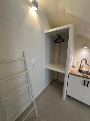 a small kitchen with a ladder and a shelf at DIONE Suite in Ermoupoli