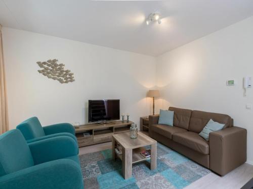 a living room with two couches and a tv at Holiday Home in Koudekerke near the Beach in Koudekerke