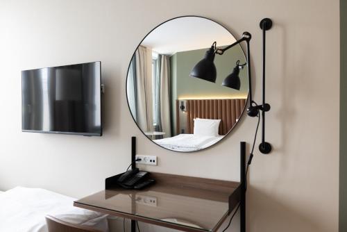 a mirror in a hotel room with a desk and a bed at Imperial Hotel in Copenhagen