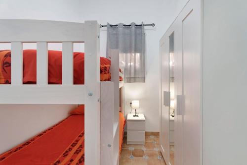 ein Schlafzimmer mit einem Etagenbett mit einer roten Tagesdecke in der Unterkunft La Sabina De Manuel in San Miguel de Abona