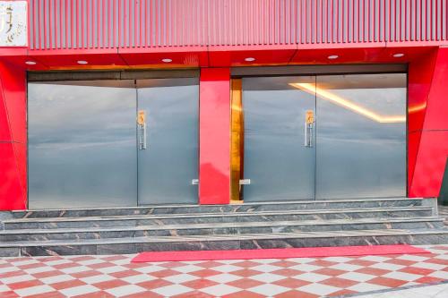 two doors on a red building with stairs in front at Collection O AIIMS Kolkata Tanishq Inn in Kalyani
