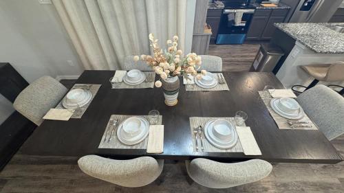 a dining room table with chairs and a vase of flowers at Modern Family Home Sleeps 8 in Dallas