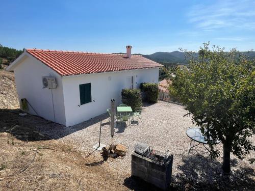 ein kleines weißes Haus mit einem Tisch und Stühlen in der Unterkunft Cottage Abrunheiro Grande in Vila de Rei